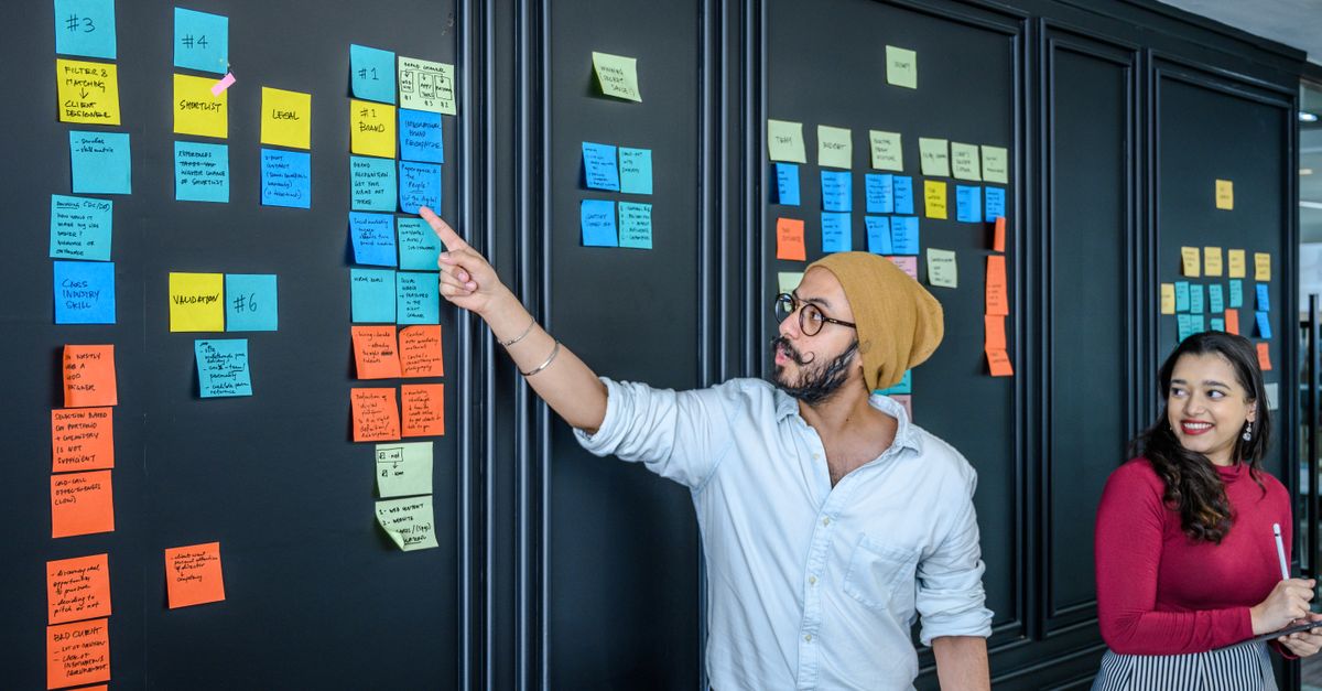 Une équipe qui planifie son calendrier de contenus avec des post-it sur un tableau