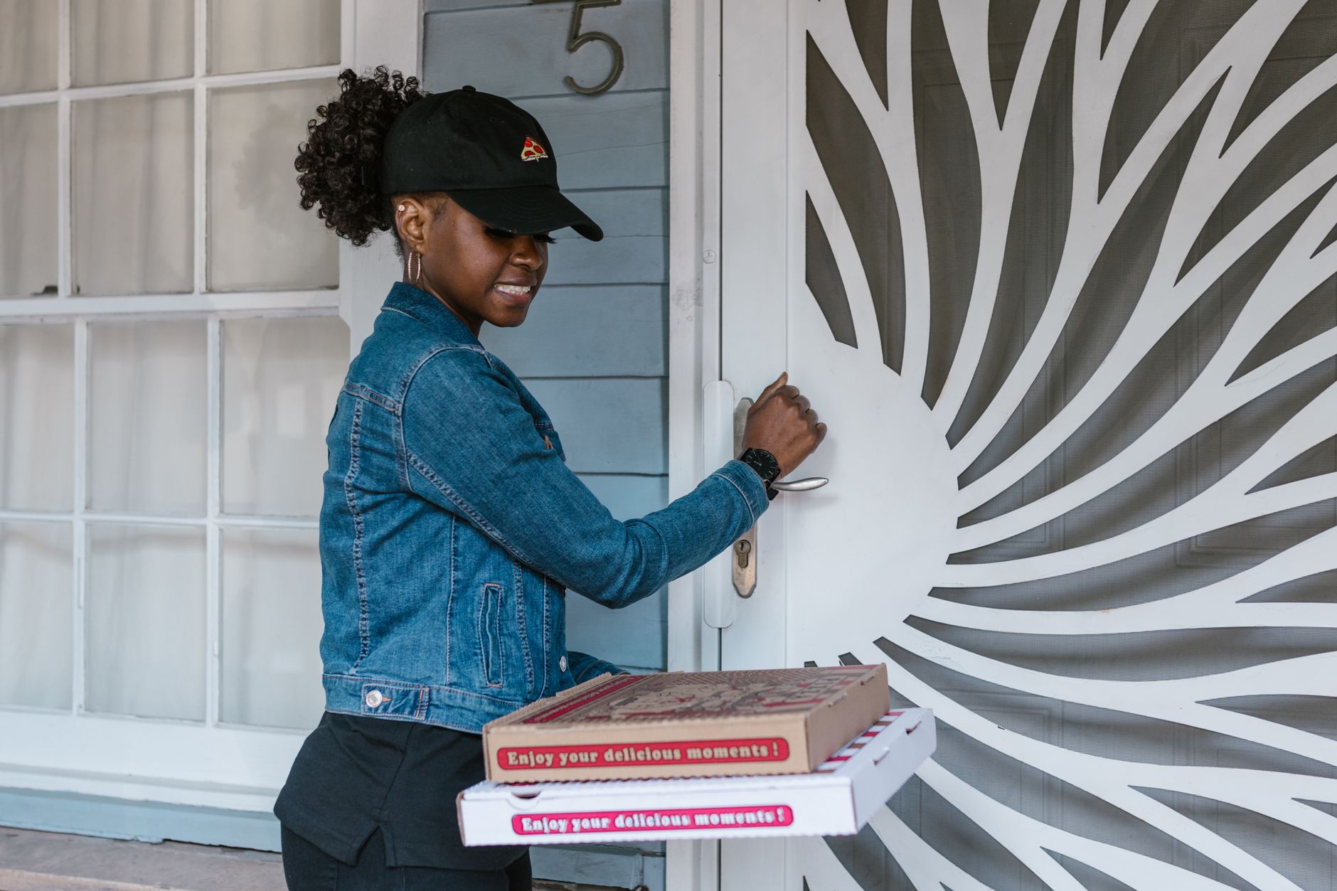 Cliente ouvrant un colis reçu chez elle, moment associé à la réception d'une nouvelle commande e-commerce