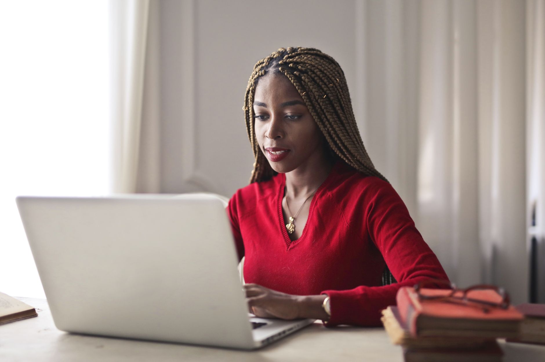 Femme concentrée qui travaille sur son ordinateur portable dans un bureau lumineux