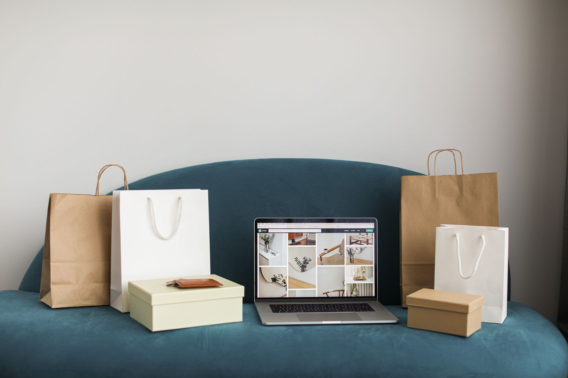 Ordinateur portable entouré de colis et de sacs, illustrant une boutique en ligne en croissance