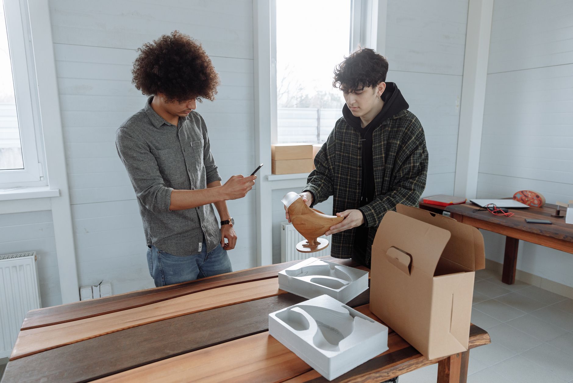 Deux artisans emballant un objet fabriqué à la main dans leur atelier