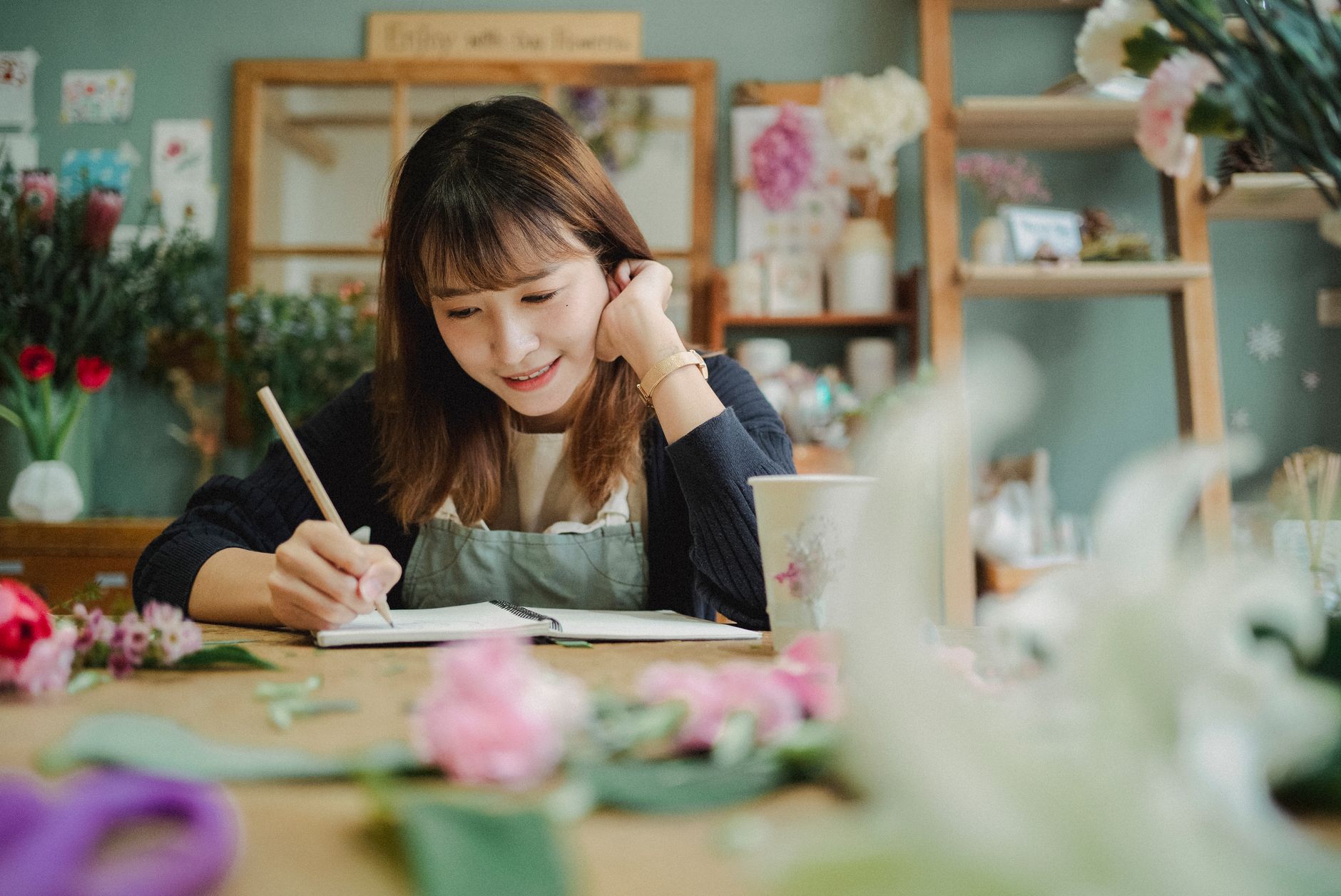Fondatrice d'une petite marque écrivant des notes dans son atelier