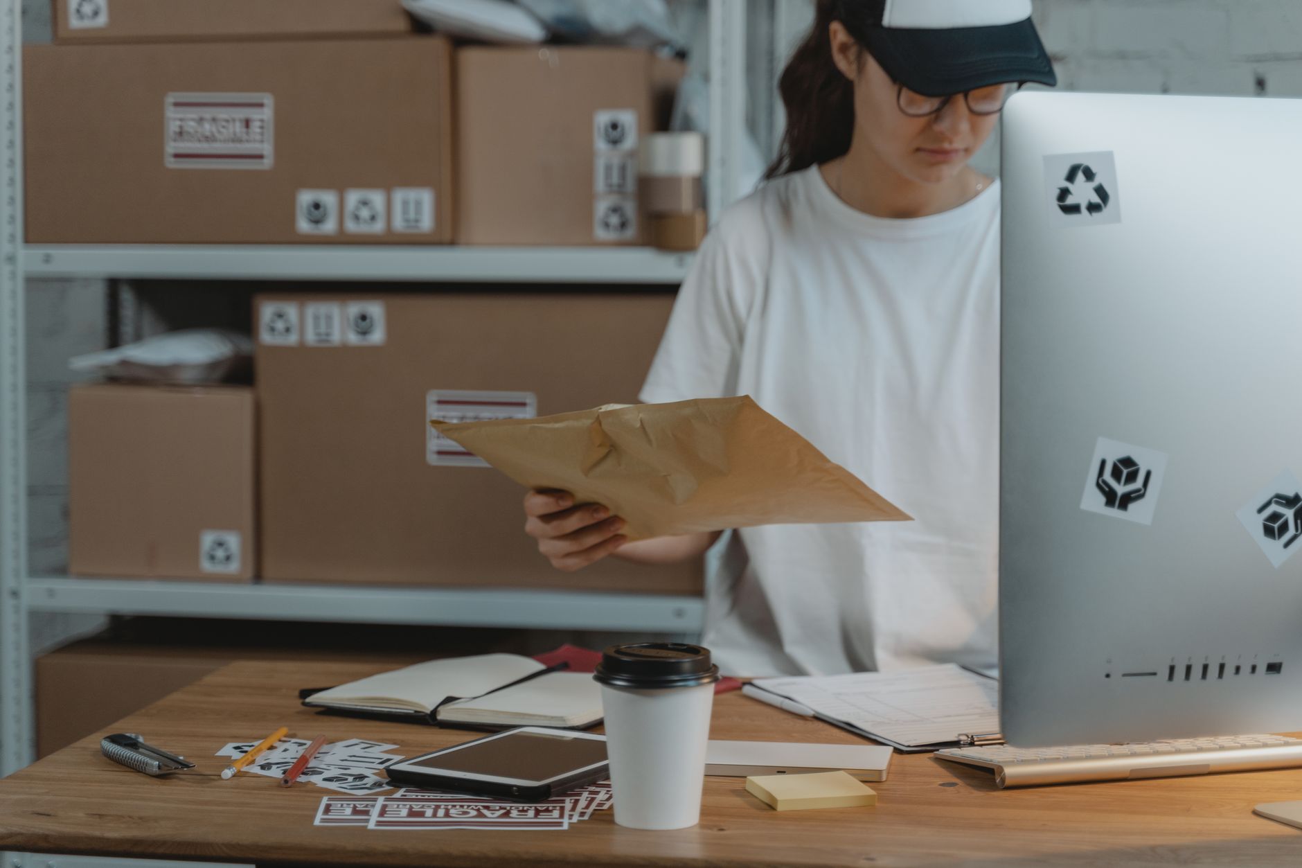 Une salariée trie des colis à son bureau dans un service logistique e-commerce
