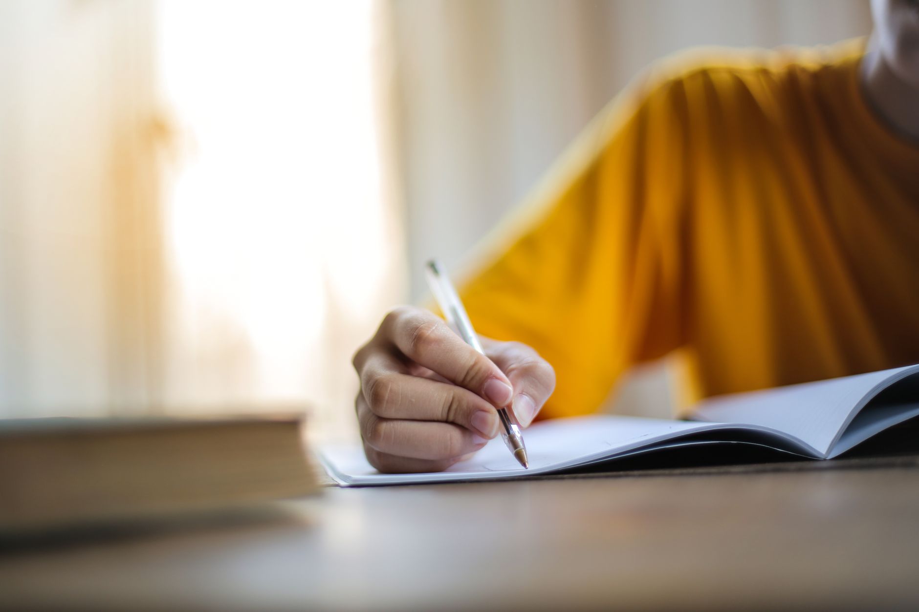 Une personne qui écrit un récit à la main dans un carnet, symbolisant la construction d'un fil narratif de marque