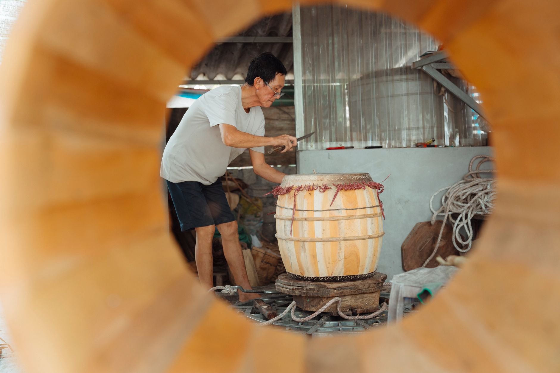 Un artisan façonne un tonneau en bois dans un atelier, illustrant un produit dont la valeur justifie le prix